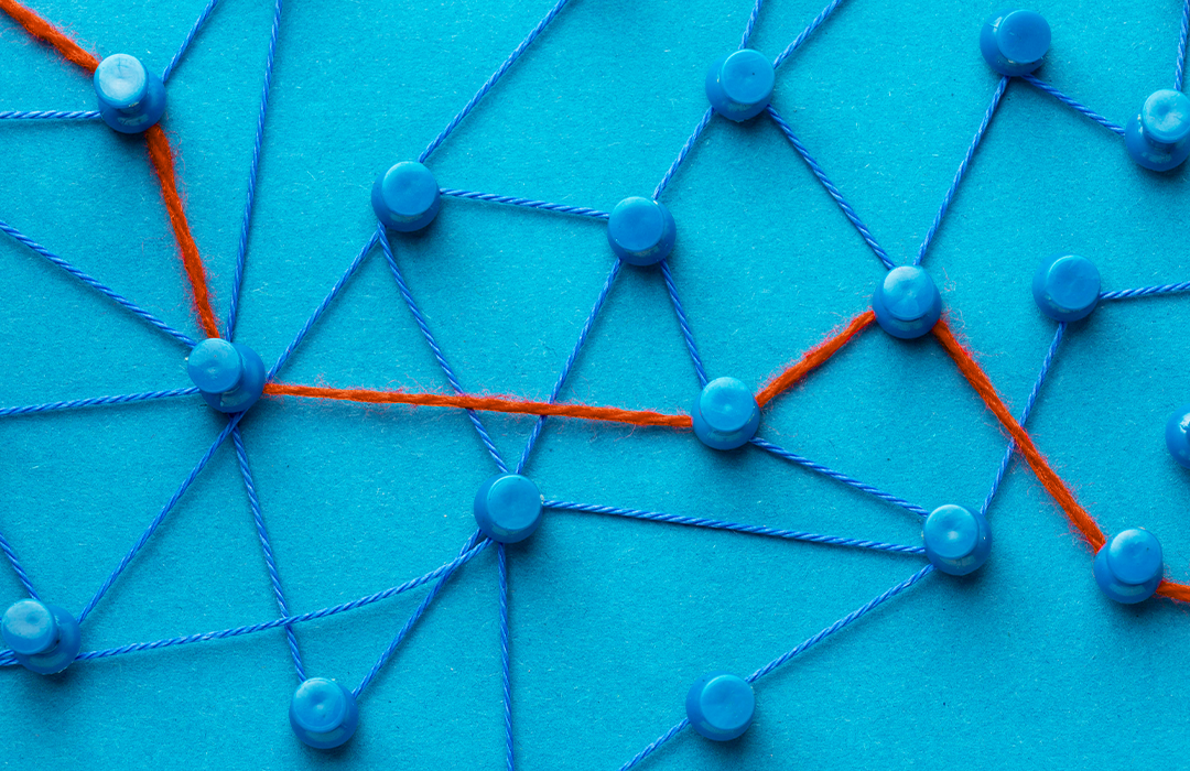 Pins attached with orange string, representing a flow path