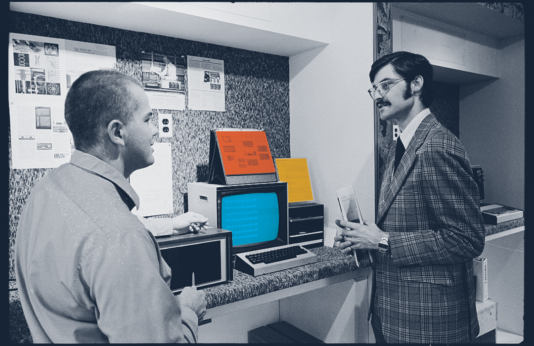 Two men discuss website optimization over a computer display 