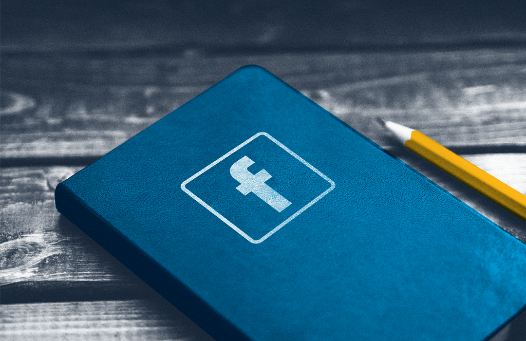 a small blue book with the facebook logo sitting on a table beside a pencil